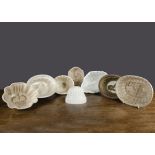 Seven pottery jelly moulds, the interior decorated with a cow being milked, a cherub, two lions, a