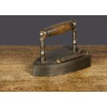 An iron box iron, possibly French, with turned wooden handle, gate catch on top of iron and slug —