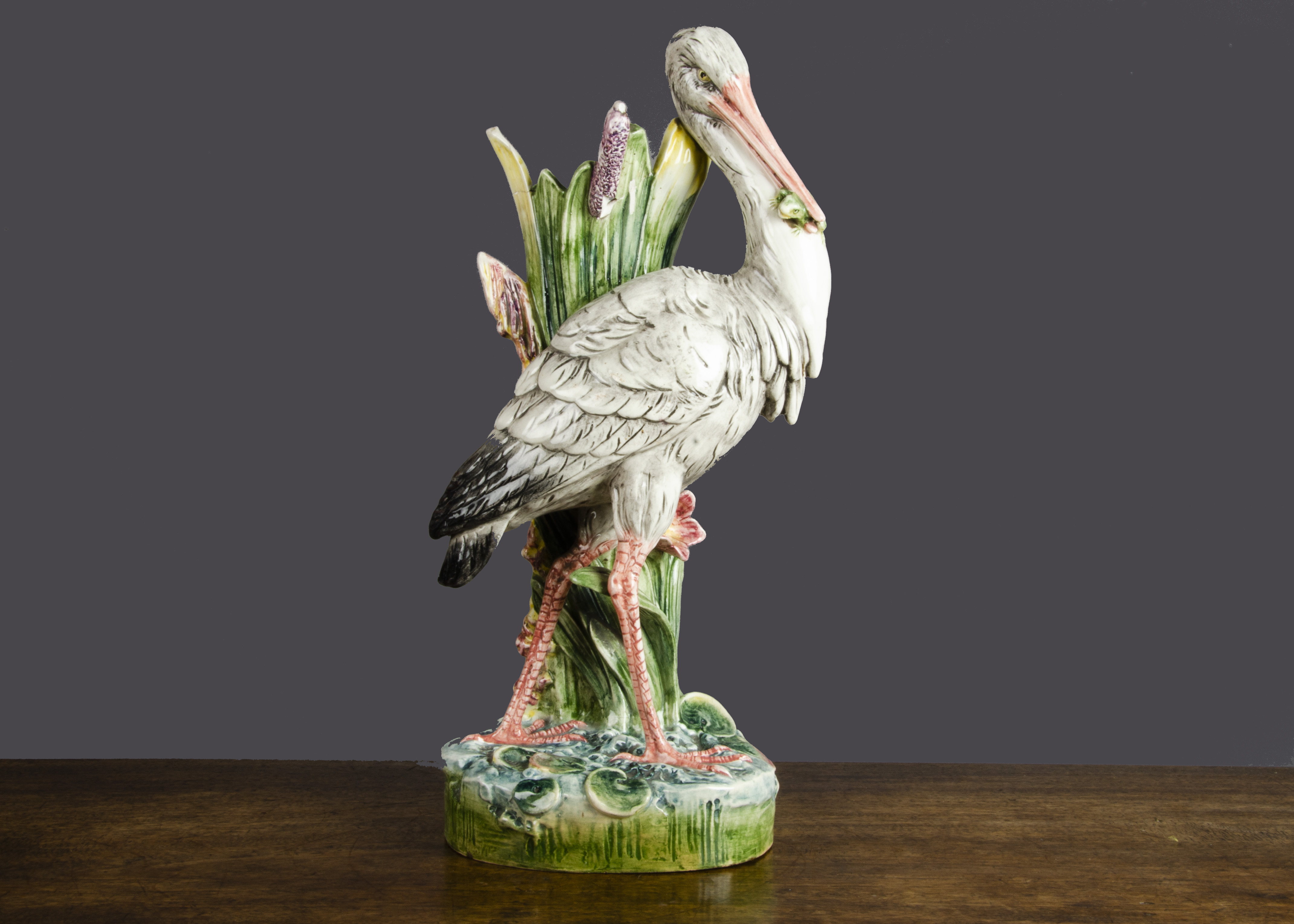 A large French Majolica heron vase, a clump of bulrush creates the vase with a walking heron in