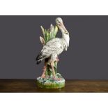 A large French Majolica heron vase, a clump of bulrush creates the vase with a walking heron in