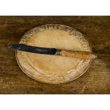 A carved wood ‘The Staff of Life’ bread board, —11¾in. (30cm.) wide; and a Sheffield bread knife