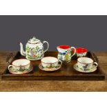 An enamel part tea set with Japanese scenes, cream ground with brightly coloured traditional figures