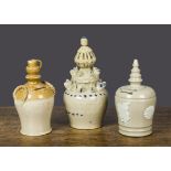 Three salt-glazed money banks, one buff and treacle glazes, the finial modelled as a jug —6¾in. (