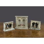Three tinplate dolls’ house fireplaces, with soft metal decoration and ‘flat’ flames and smoke in