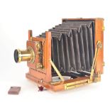 An early 20th Century mahogany and brass half-plate Field Camera, with roller-blind shutter and