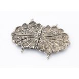 A silver plated Art Nouveau nurses belt buckle, the shaped outline with scroll and leaf design