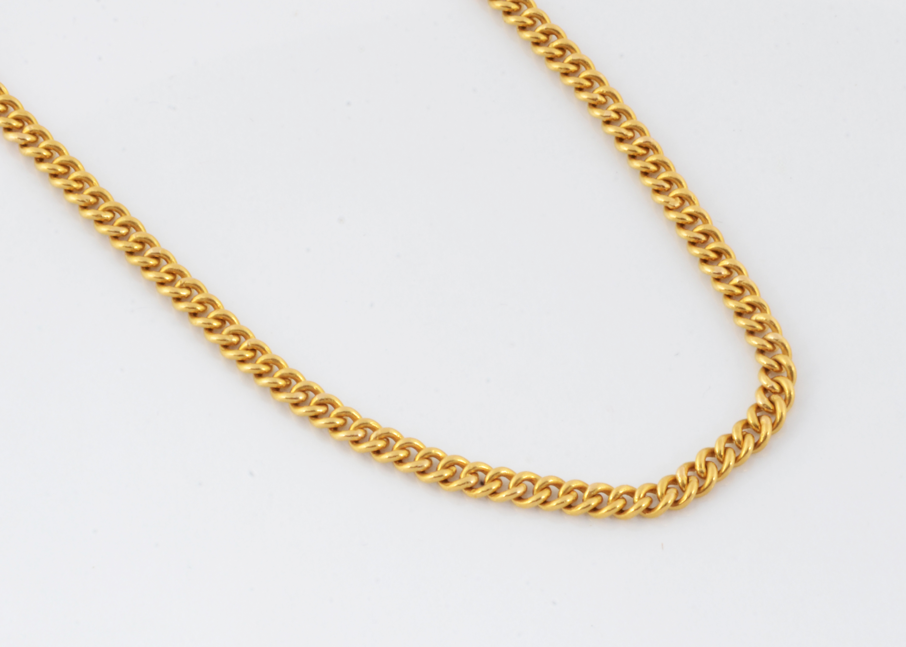 A continental flattened curb linked yellow metal necklace, the S shaped clasp marked 22, 51cm, 44g