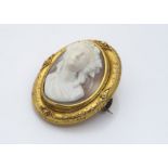 A 19th Century shell cameo modelled as a female face emerging with floral headdress, within an