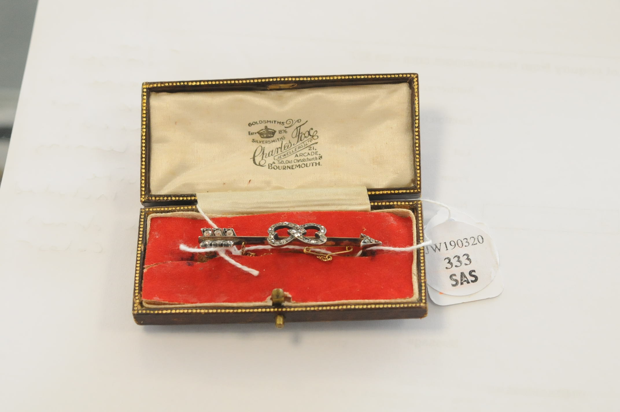 An Edwardian diamond set gold sweetheart brooch, of arrow form, the shaft with entwined hearts