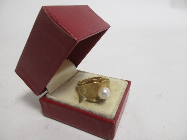 A Continental yellow metal and cultured pearl dress ring, the textured yellow metal mount of ovoid