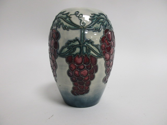 A contemporary Moorcroft pottery vase, a trial piece with tube lined decoration of red grapes upon a
