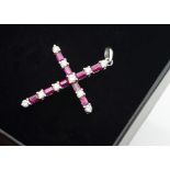 An 18ct white gold ruby and diamond cross pendant, the brilliant cut diamonds alternately set with