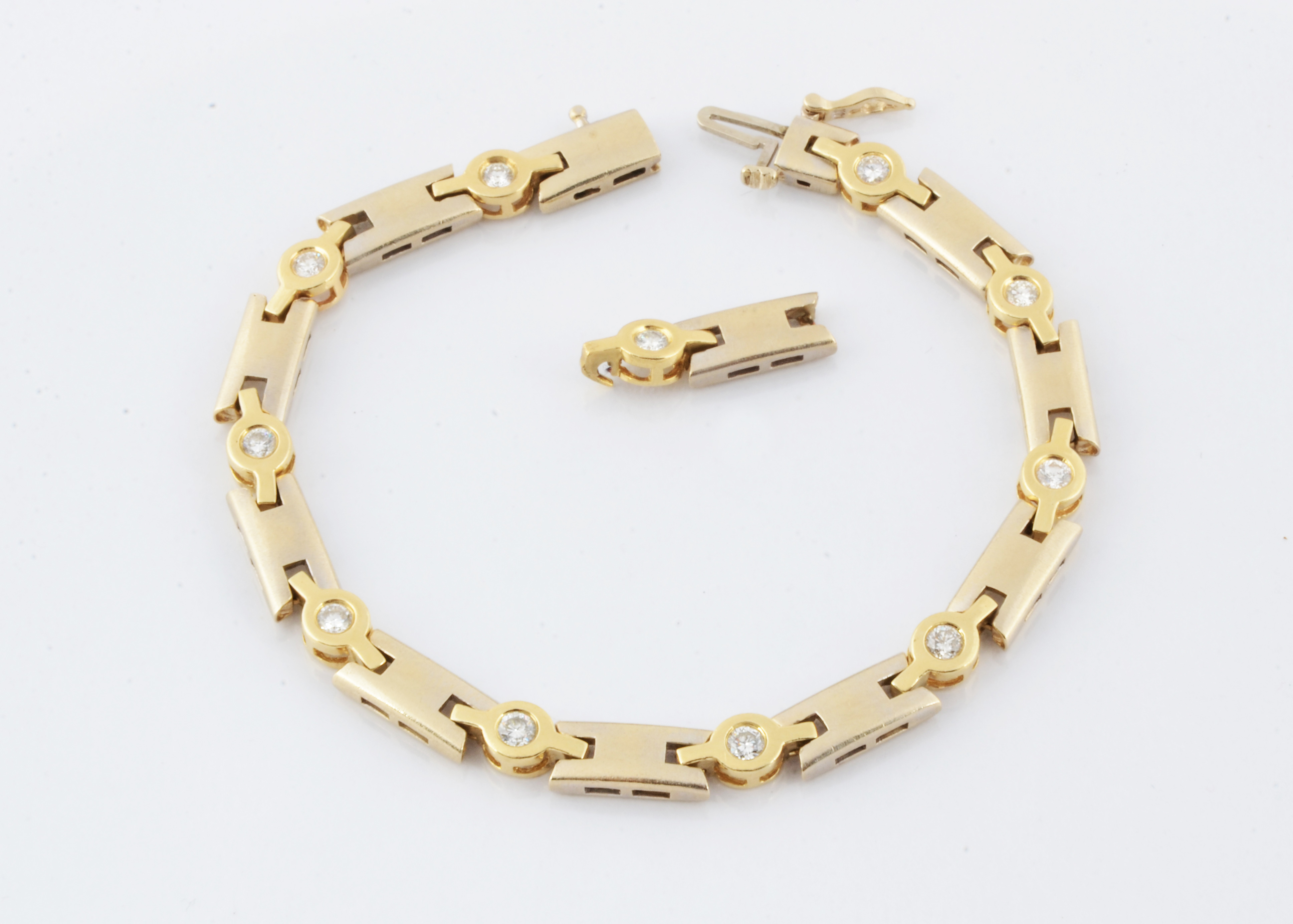 A lady's 14ct two colour gold diamond bracelet, the white metal batons alternately set with yellow