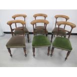 A set of six Victorian mahogany dining chairs, upholstered in a green fabric, raised on turned front