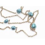 A 9ct gold and turquoise Edwardian opera length chain, the circular links interspersed with