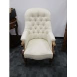 A 19th Century button back armchair, with oak scroll arms and turned supports, upholstered in an