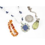 A collection of various costume jewels, including a silver brooch, a lapis lazuli, rock crystal