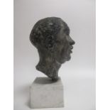 A contemporary composite bust of a man, with black and grey metal alloy glaze, on a square white