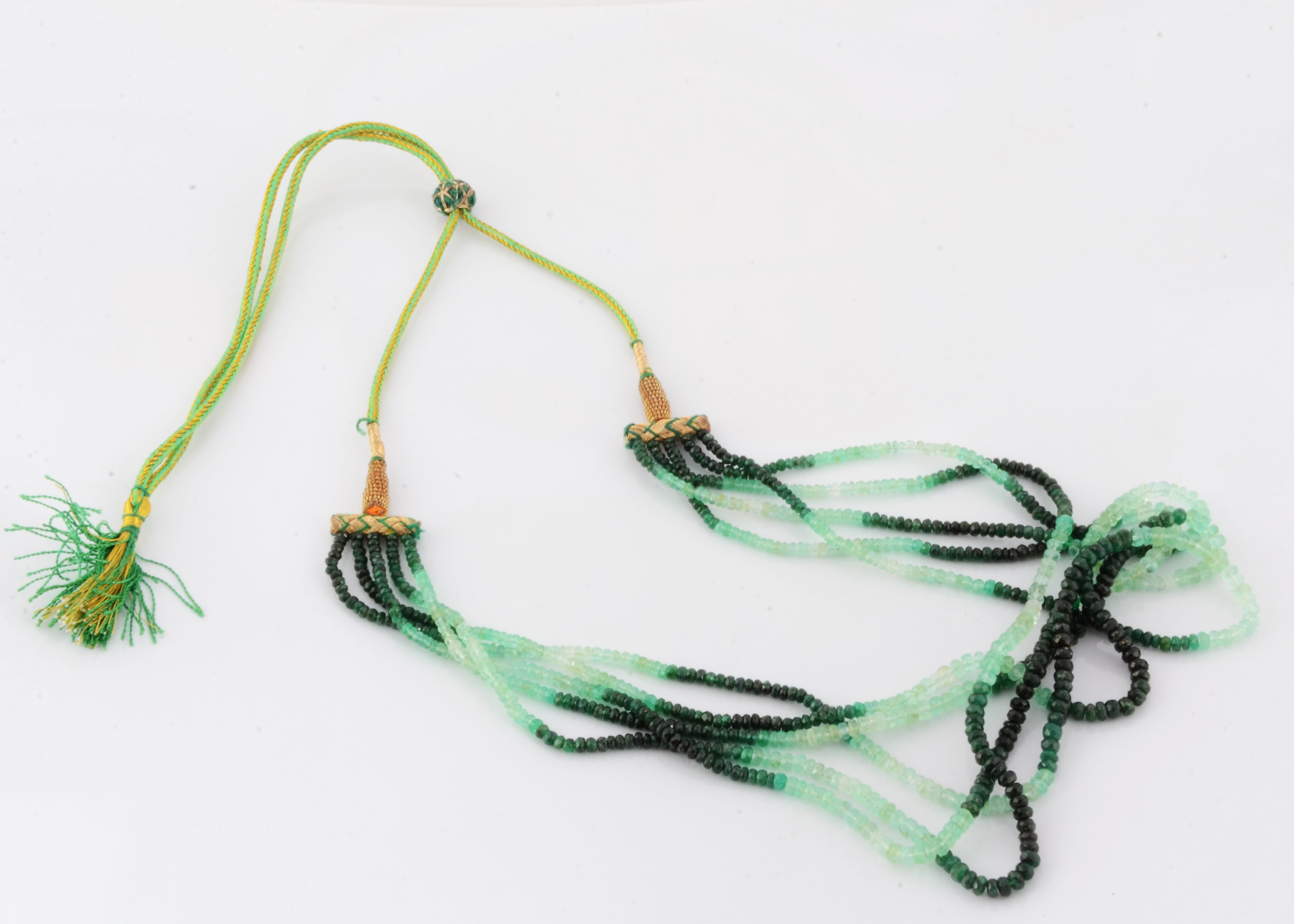 An emerald five strand necklace, on a silk and gold thread adjustable cord, emerald beads in