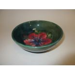 A Moorcroft pottery footed bowl, in the 'Hibiscus' pattern on green ground, impressed factory