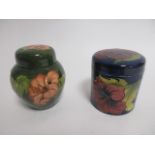 Two Moorcroft pottery lidded pots, both in the 'Hibiscus' pattern, one of spherical form with red
