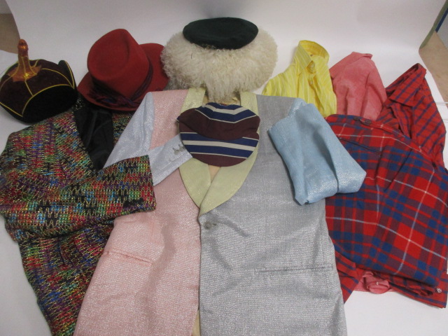 A collection of novelty clothing, including two metallic jackets, a pair of tartan trousers, five