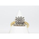 An 18ct gold diamond cluster ring, the brilliant cuts in claw tablet setting, with waisted shoulders