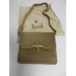 A vintage Gucci beige suede shoulder bag, with a brown leather adjustable strap and gilt metal clasp
