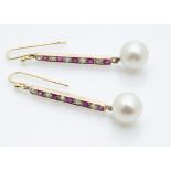 A pair of ruby diamond and pearl drop earrings, the cultured pearl drops supported on a baton of