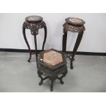 Two contemporary Oriental jardinière stands, with carved decoration and marble inserts to top,