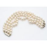 A four strand cultured pearl bracelet united by white metal fittings, 16cm