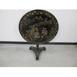 A 20th Century black tripod tilt top table with chinoiserie decoration, depicting a lakeside