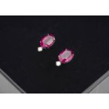 A pair of ruby and diamond platinum stud earrings, the oval mixed cut rubies, with diamond claw