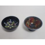 Two Moorcroft pottery bowls, one of tapered circular form, in the 'Pomegranate' pattern against a