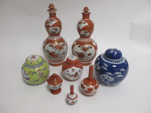 Two early 20th Century Japanese Kutani pattern double gourd shaped covered vases, with gilt orange