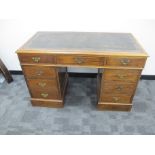 An early 20th Century oak knee hole pedestal desk, with two short and one long drawers to top,