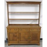 A 20th Century solid oak dresser, open back with two shelves, the base with three short drawers