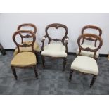 A set of four Victorian balloon back dining chairs, with carved central splat, raised on front