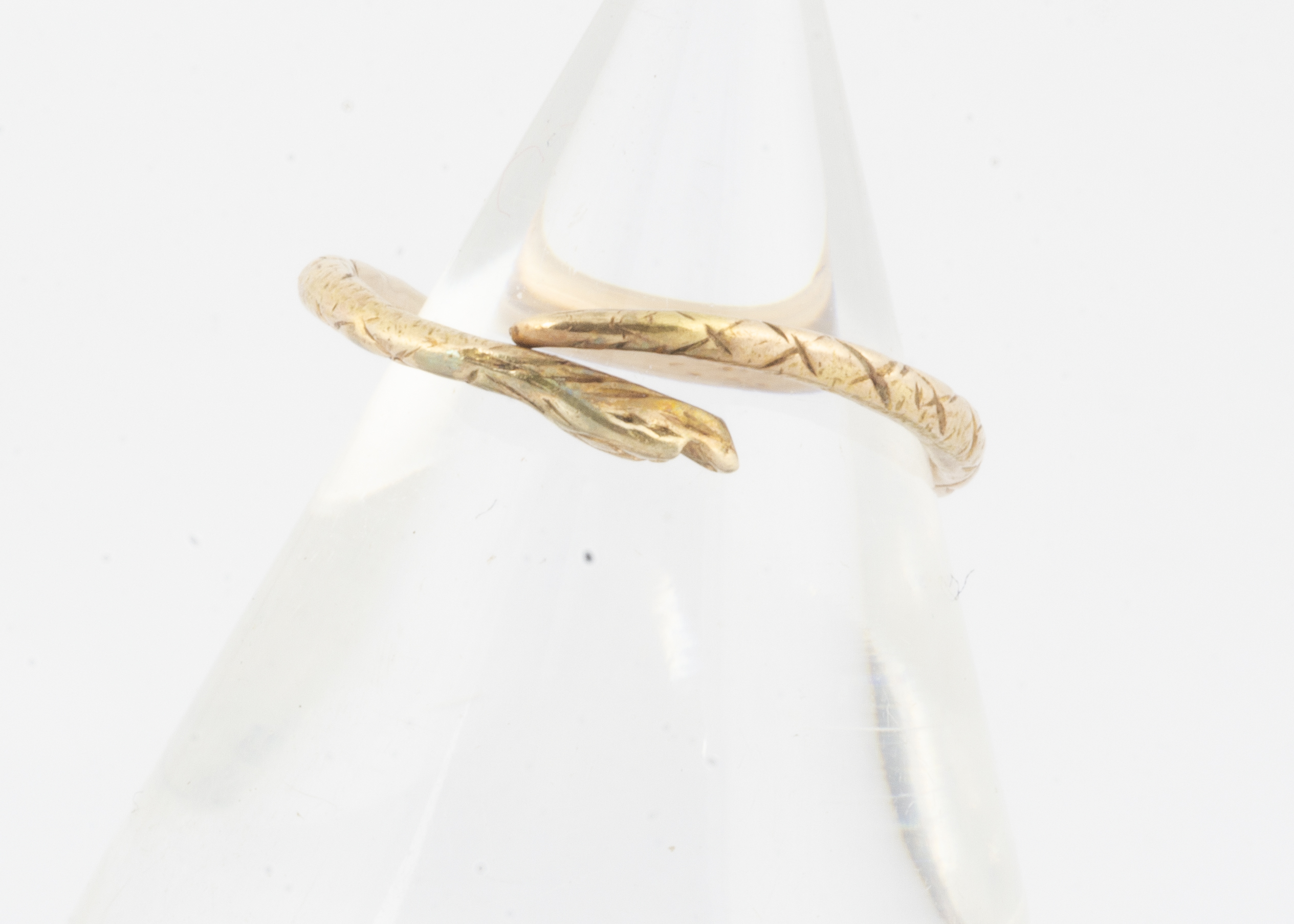 An antique yellow metal Ouroboros ring, the yellow metal shank of split form meeting at the snake'