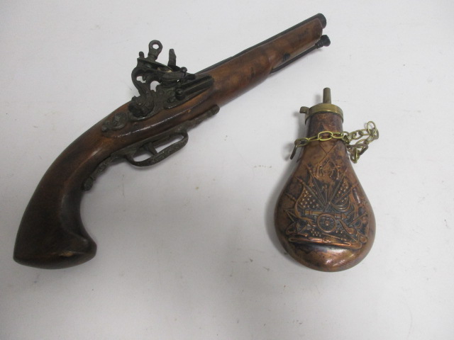 A novelty pistol and another novelty powder/shot flask, with field artillery and crossed rifle