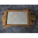 A 19th Century walnut fret carved wall mirror, with parcel-gilt border to bevelled plate, 46cm x