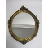 A giltwood framed oval mirror in the rococo style, length 66cm