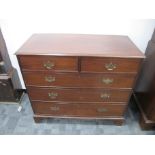 A Georgian mahogany chest of two short and three long graduate drawers, cross banded top, raised