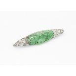 An Art Deco diamond, jade, platinum and 18ct gold brooch, the central Chinese carved green jade oval