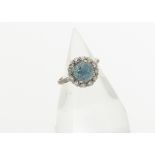 A zircon and diamond cluster dress ring, the circular mixed cut blue zircon in a four claw setting