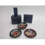 A selection of Moorcroft pottery, including two plates, one in the 'Pansy' pattern, the other in the