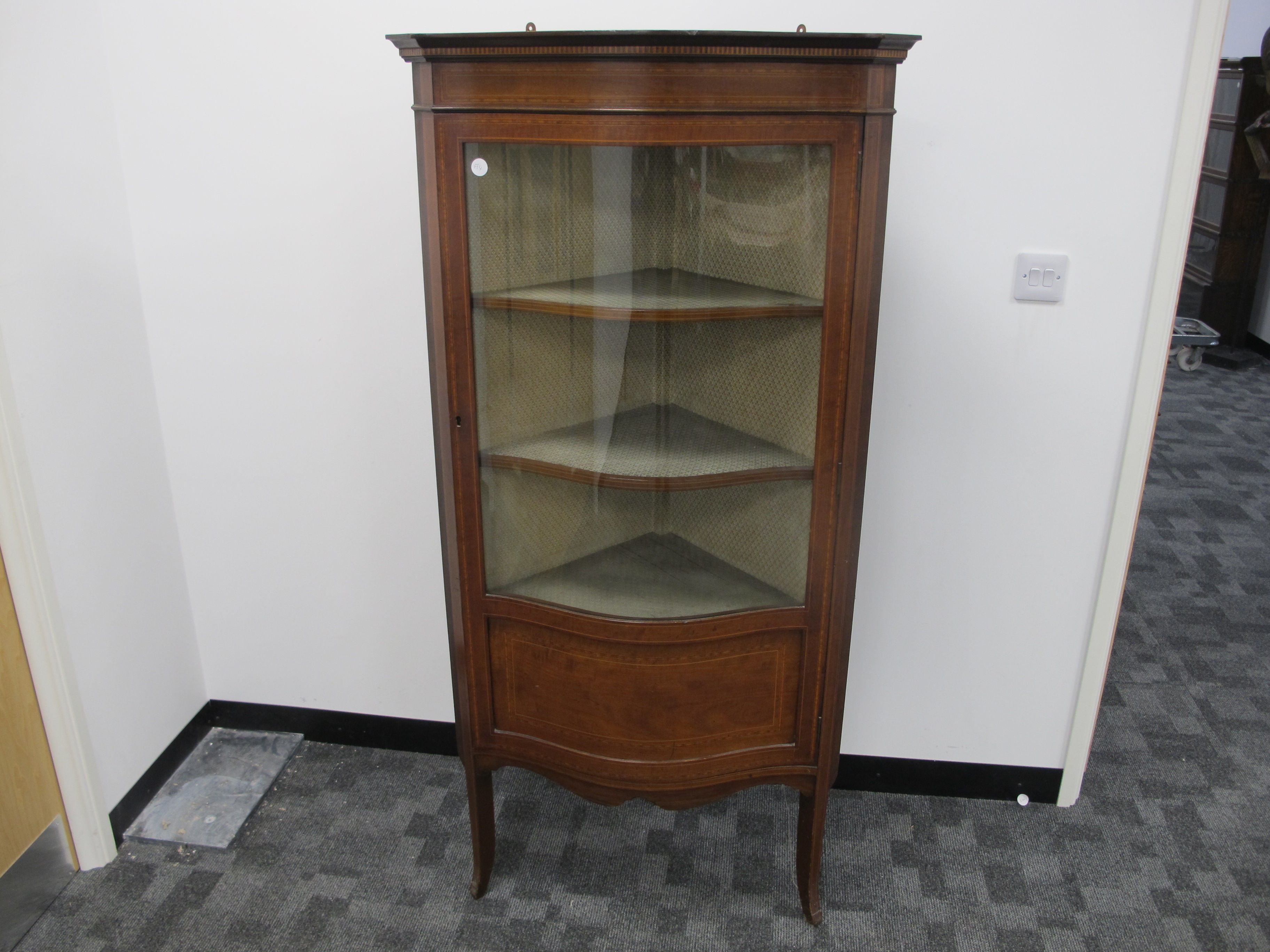 A Edwardian inlaid mahogany serpentine corner display cabinet, with cross banding and stringing,