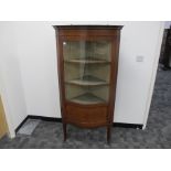 A Edwardian inlaid mahogany serpentine corner display cabinet, with cross banding and stringing,