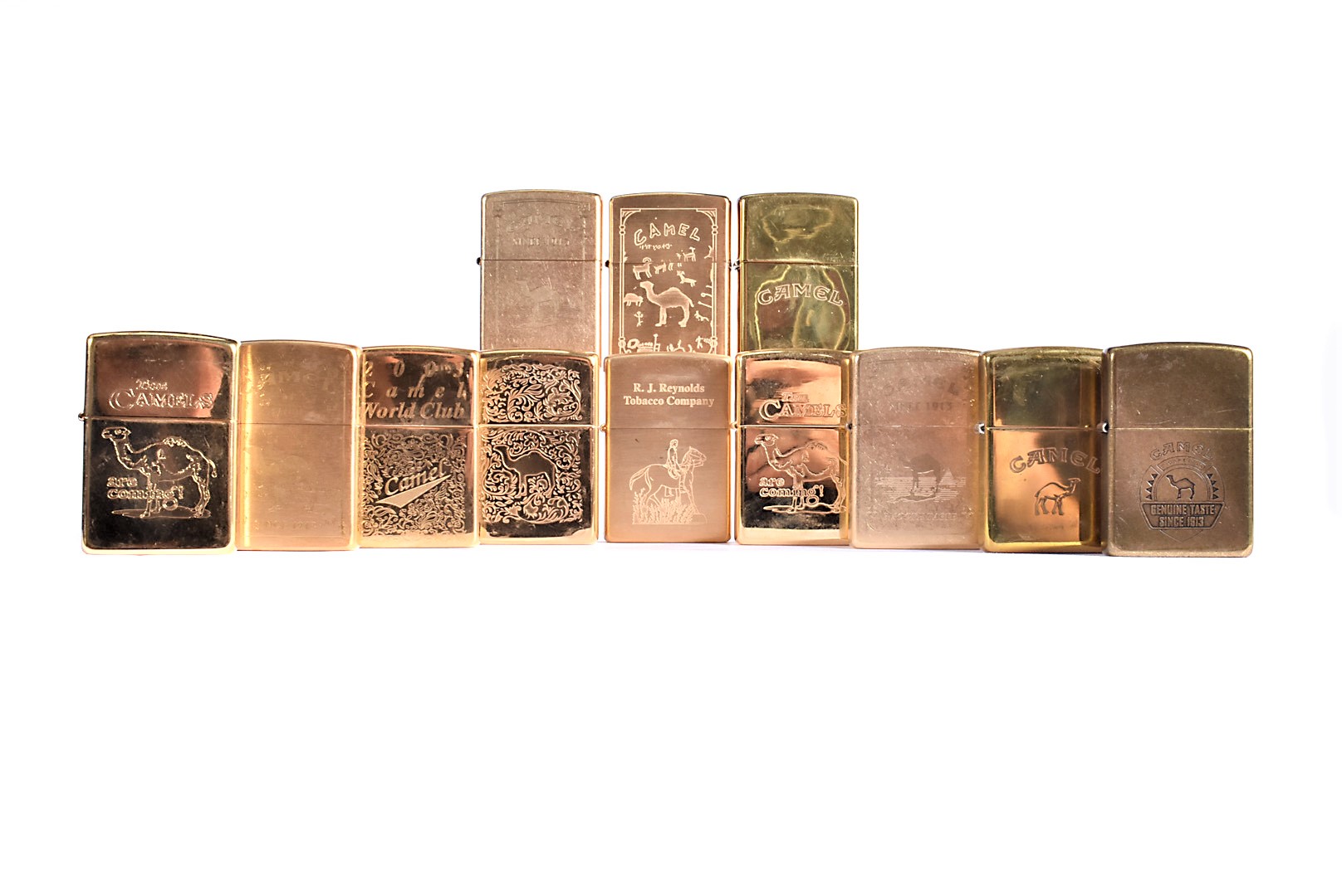 A collection of twelve yellow metal Camel Zippo Lighters, dating 1996-2008, with various designs,