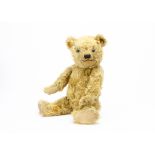 A 1930s Chiltern Hugmee musical teddy bear, with golden mohair, clear and black glass eyes with